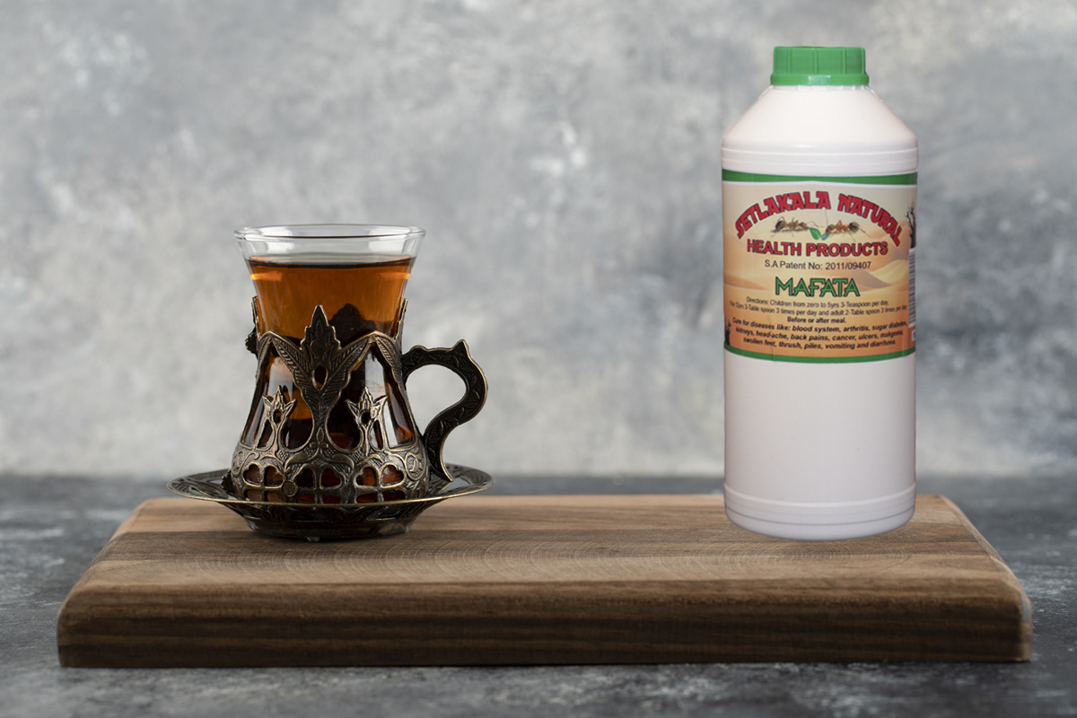 A glass cup of hot tea on a wooden cutting board . High quality photo