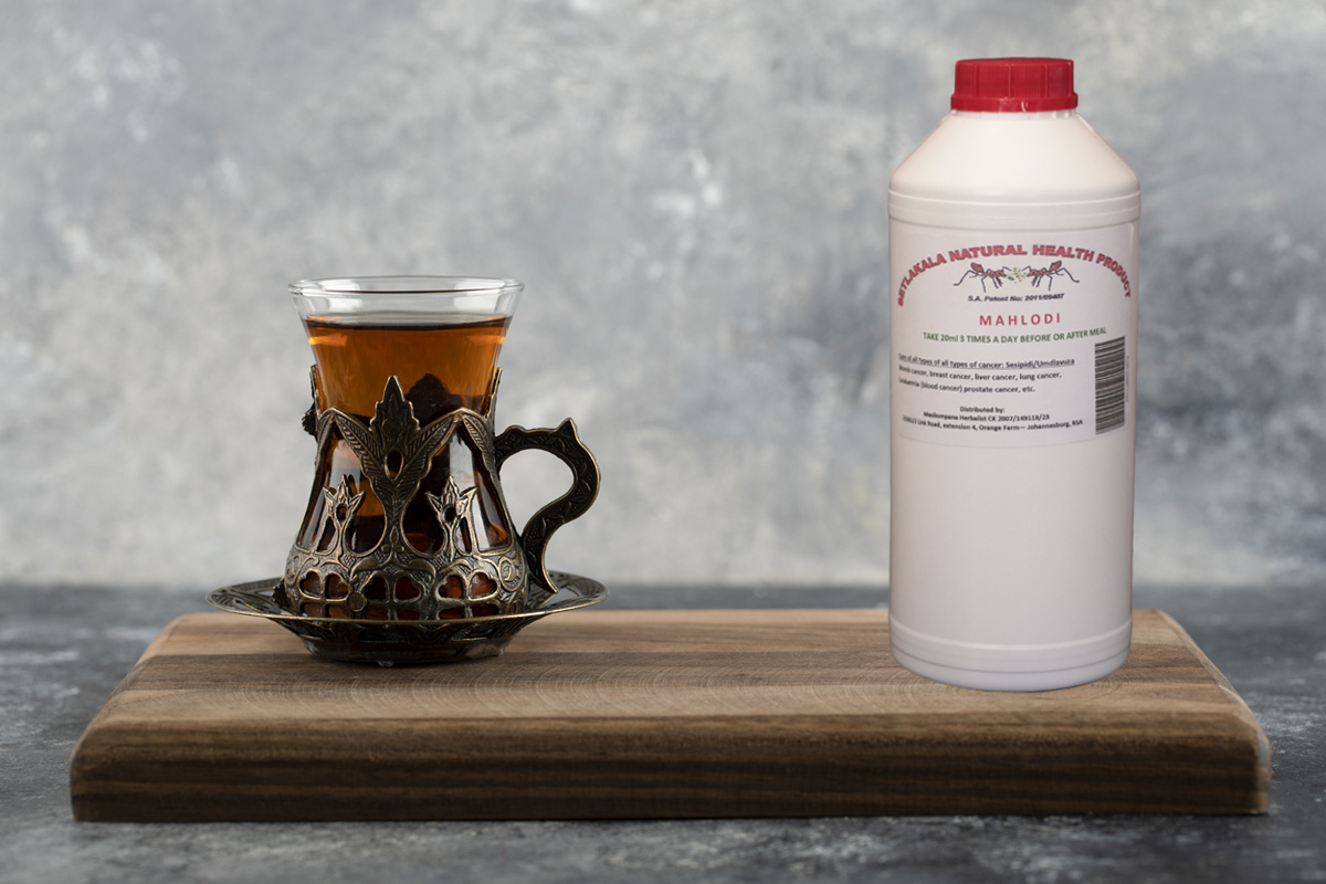 A glass cup of hot tea on a wooden cutting board . High quality photo